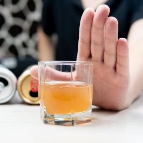 Hand raised to refuse alcohol — choosing abstinence