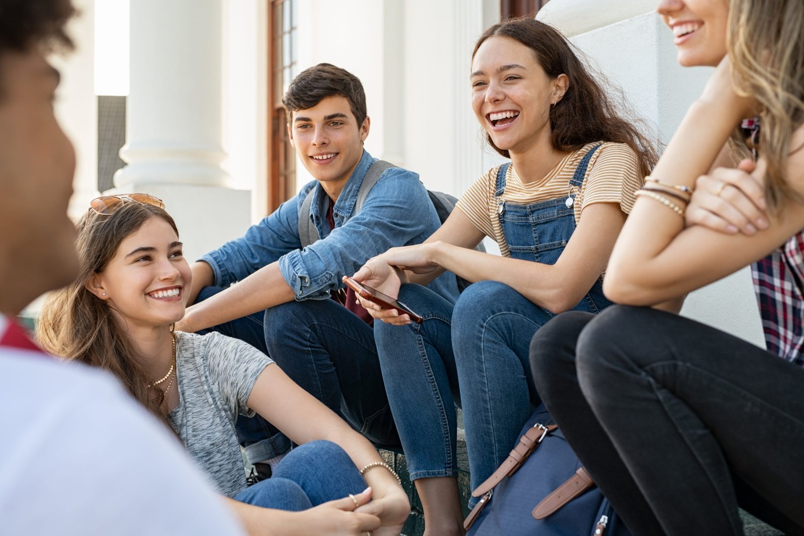 Happy young friends sitting together