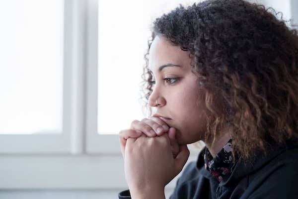 Young woman reflecting by window — understanding women's substance use