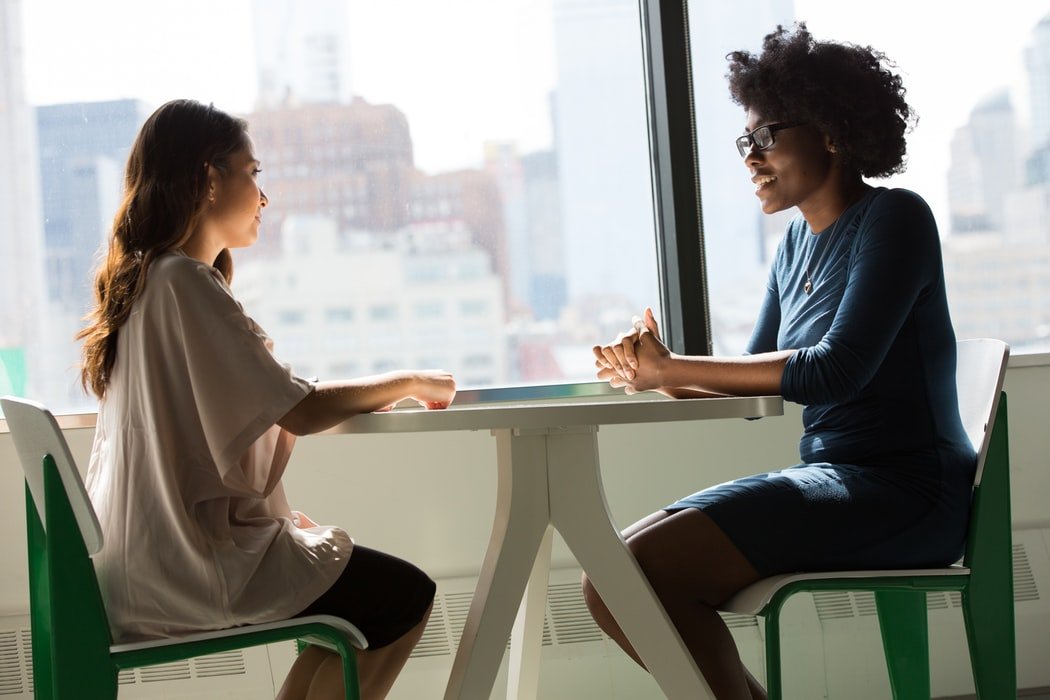 Two women having a supportive conversation — women's addiction treatment